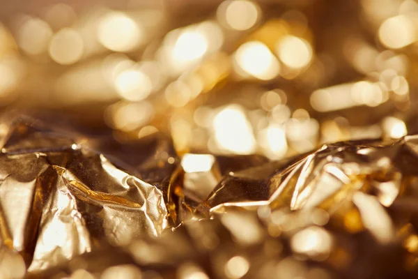 Selrctive focus of golden foil with bright sparkling lights — Stock Photo