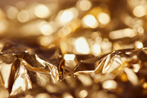 Foyer sélectif de feuille d'or avec des lumières scintillantes lumineuses — Photo de stock