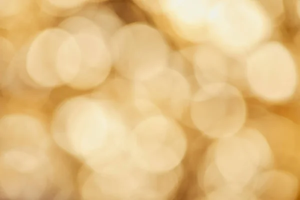 Bright sparkles on blurred golden background — Stock Photo