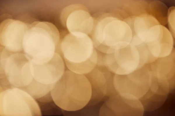 Brilhos dourados borrados no fundo escuro — Fotografia de Stock