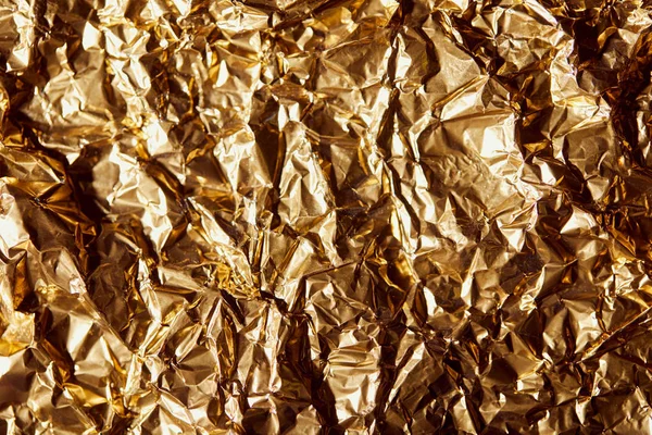 Creased golden foil sheet with twinkles — Stock Photo