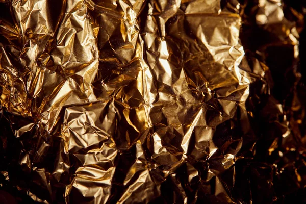 Creased golden foil with twinkles in shadows — Stock Photo