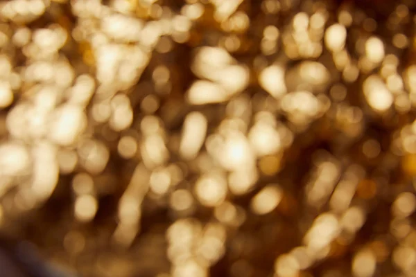 Fundo dourado com brilhos brilhantes borrados e brilhos — Fotografia de Stock