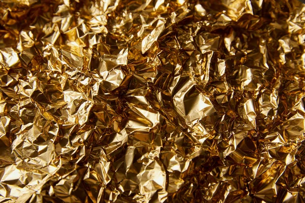 Draufsicht auf zerknüllte Goldfolie mit Funkeln — Stockfoto