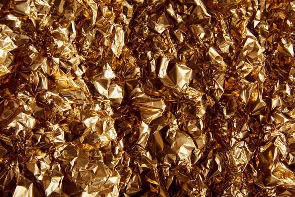 Draufsicht auf zerknüllte Goldfolie mit Funkeln — Stockfoto