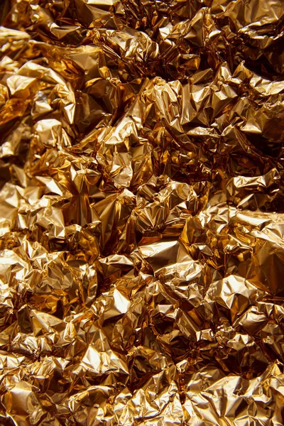 Crumpled golden foil with glares and sparkles — Stock Photo