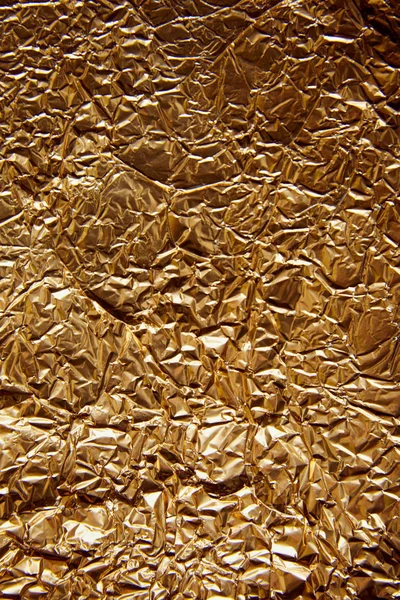 Top view of rumpled sheet golden foil with glares — Stock Photo