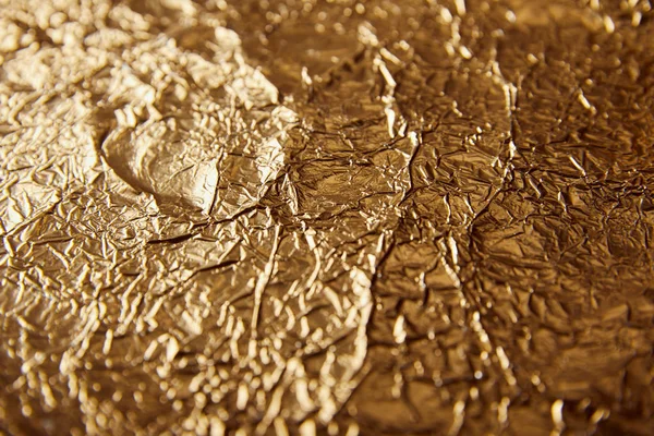 Sheet golden foil with blurred bright glares — Stock Photo
