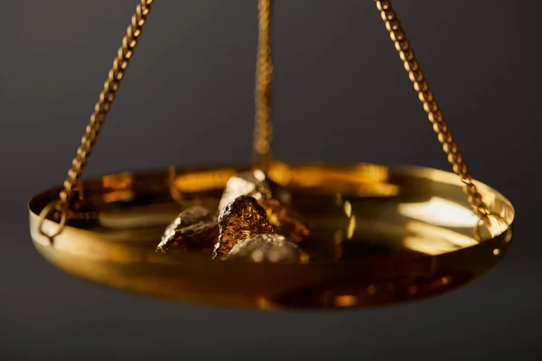 Selective focus of golden stones on scales on dark background — Stock Photo