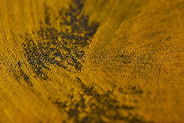 Различные мазки золотой краски на сером холсте — стоковое фото
