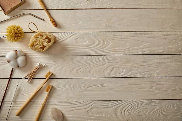 Vista dall'alto di diversi articoli per l'igiene e la cura sulla superficie in legno bianco, concetto di zero rifiuti — Foto stock