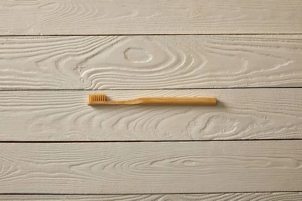 Вид зверху зубної щітки на білій текстурованій дерев'яній поверхні, концепція нульових відходів — стокове фото