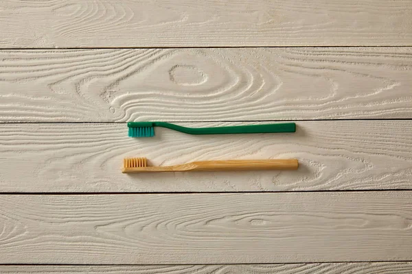 Top view of toothbrushes on white wooden surface, zero waste concept — Stock Photo