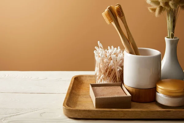 Holztablett mit verschiedenen Hygiene- und Pflegeartikeln und Vase mit Stacheln auf weißer Holzoberfläche, Zero-Waste-Konzept — Stockfoto