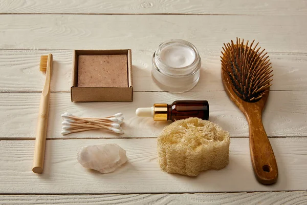 Colocação plana de itens de higiene e cosméticos na superfície de madeira branca, conceito de resíduo zero — Fotografia de Stock