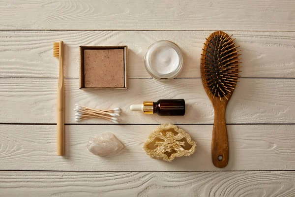 Top view of various hygiene and cosmetic items on white wooden surface, zero waste concept — Stock Photo