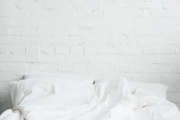 Cama vacía y acogedora con almohadas blancas y manta - foto de stock