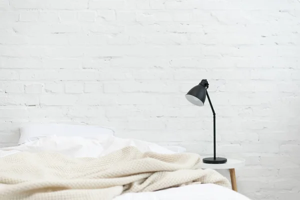 Lampada vicino bianco letto vuoto con cuscino e coperta — Foto stock