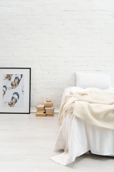 Dormitorio con almohada en cama vacía y libros, foto en el suelo - foto de stock