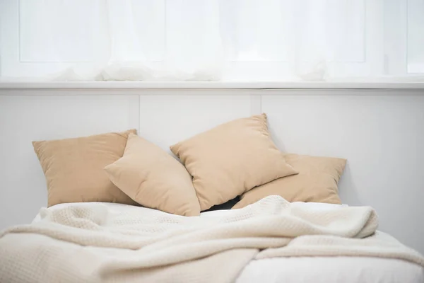 Letto vuoto con cuscini marroni e coperta bianca — Foto stock