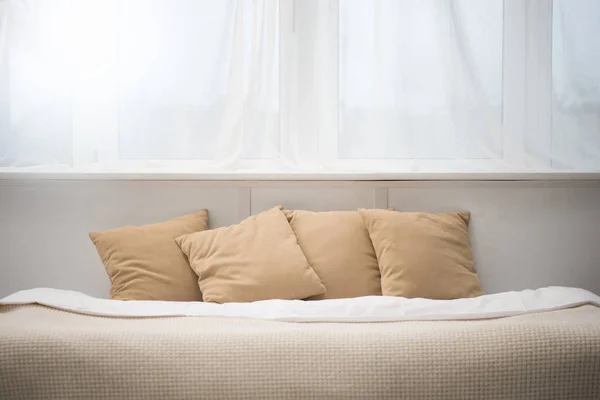 Bedroom with brown pillows and white blanket on empty bed — Stock Photo