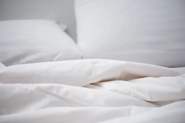 Focus selettivo del letto vuoto con coperta bianca e cuscino — Foto stock
