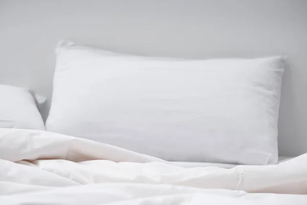 Enfoque selectivo de la cama con almohada blanca y manta - foto de stock