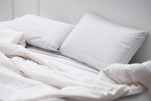 Cama vacía con almohadas blancas y manta - foto de stock