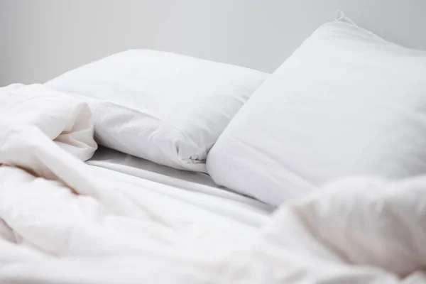 Enfoque selectivo de la cama vacía con almohadas blancas y manta - foto de stock