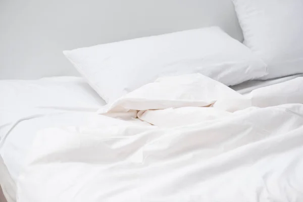 Cozy bed with white pillows and blanket — Stock Photo