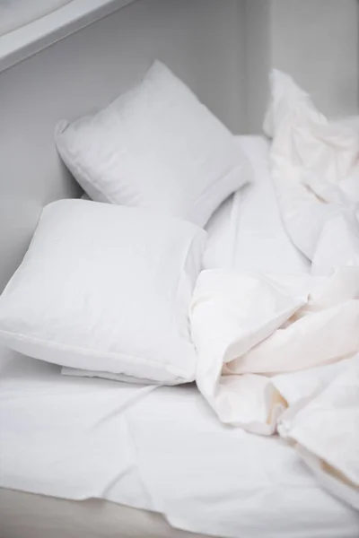 Enfoque selectivo del dormitorio con almohadas blancas y manta en la cama - foto de stock