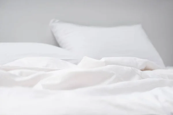 Вибірковий фокус порожнього ліжка з білими подушками і ковдрою — стокове фото
