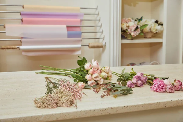 Rosas blancas y peonías rosadas en la mesa - foto de stock