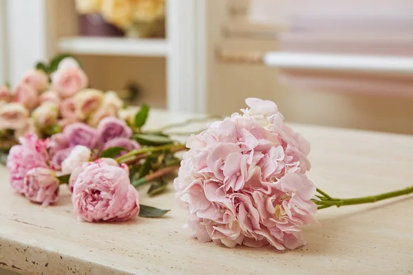 Foco seletivo de rosas e peônias cor-de-rosa na mesa — Fotografia de Stock