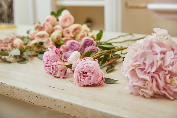 Foco seletivo de rosas e peônias rosa na superfície — Fotografia de Stock