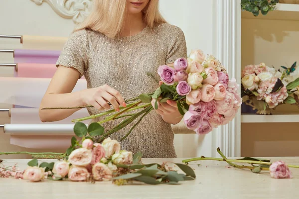 Vista parcial de florista fazendo buquê de rosas e peônias no espaço de trabalho — Fotografia de Stock