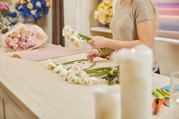 Partial view of florist making bouquet of white peonies at flower shop — Stock Photo