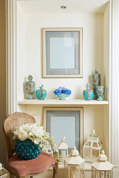 Intérieur de la chambre avec chaise, cadres photo, bouquets et mis sur étagère — Photo de stock