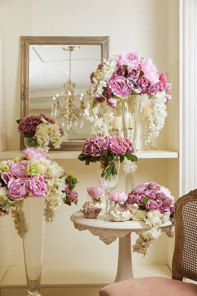 Interior de la habitación con silla, espejo, flores en floreros - foto de stock