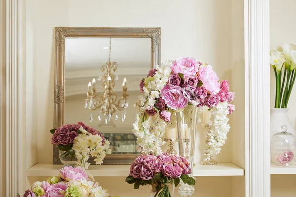 Miroir, fleurs blanches et violettes dans des vases en verre — Photo de stock