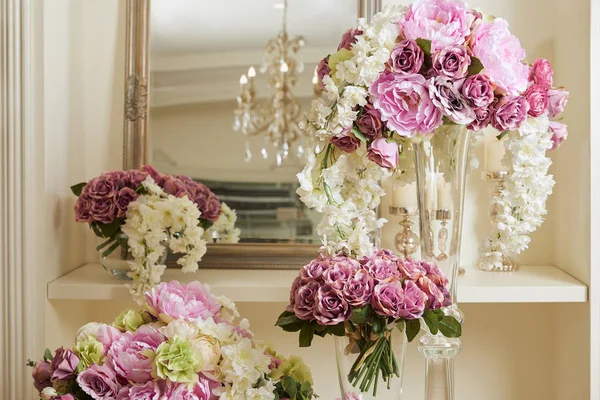 Espejo, flores blancas y moradas en jarrones de vidrio - foto de stock