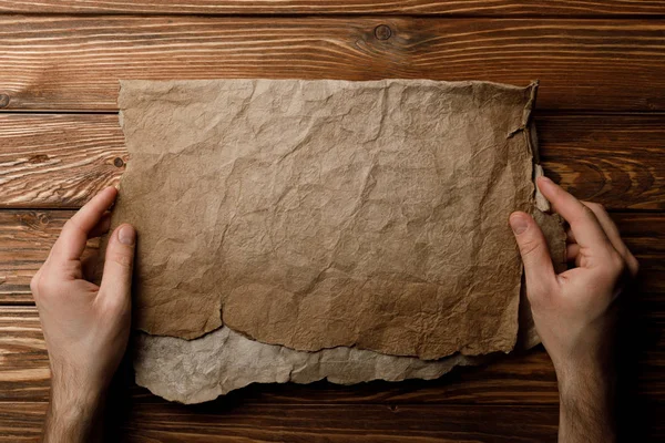 Ausgeschnittene Ansicht eines Mannes, der ein altes Pergamentblatt in Händen hält — Stockfoto