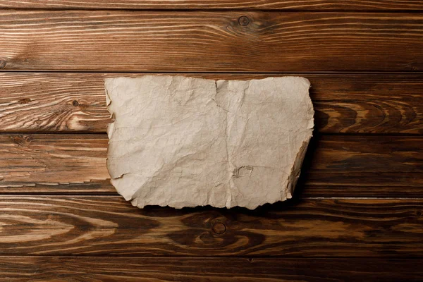 Hoja de pergamino envejecido marrón sobre fondo de madera - foto de stock