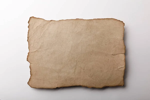 Top view of old parchment sheet lying on white background — Stock Photo