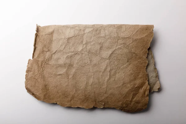 Top view of old parchment paper lying on white background — Stock Photo