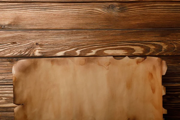 Vue de dessus de la feuille de papier antique couché sur fond en bois — Photo de stock