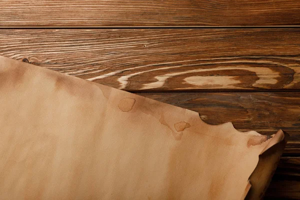 Vista dall'alto di antico foglio di pergamena disteso su sfondo di legno — Foto stock