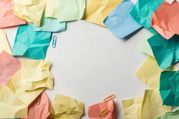 Vista superior de papéis coloridos perto de clipes de papel no fundo branco — Fotografia de Stock