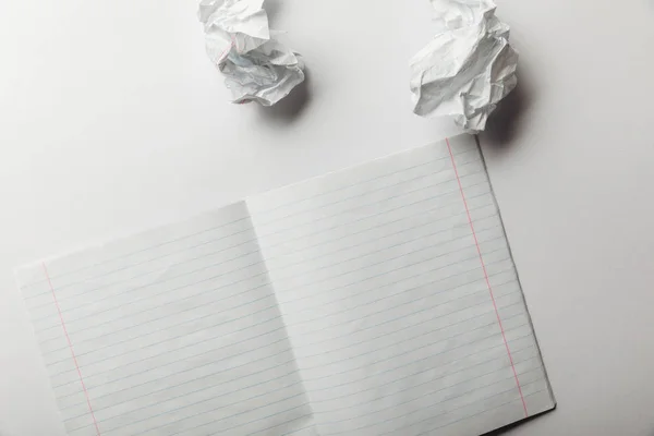 Top view of blank lined sheet lying near crumpled papers on white background — Stock Photo