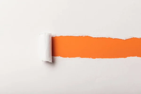 Papel blanco desgarrado con borde enrollado sobre fondo naranja - foto de stock